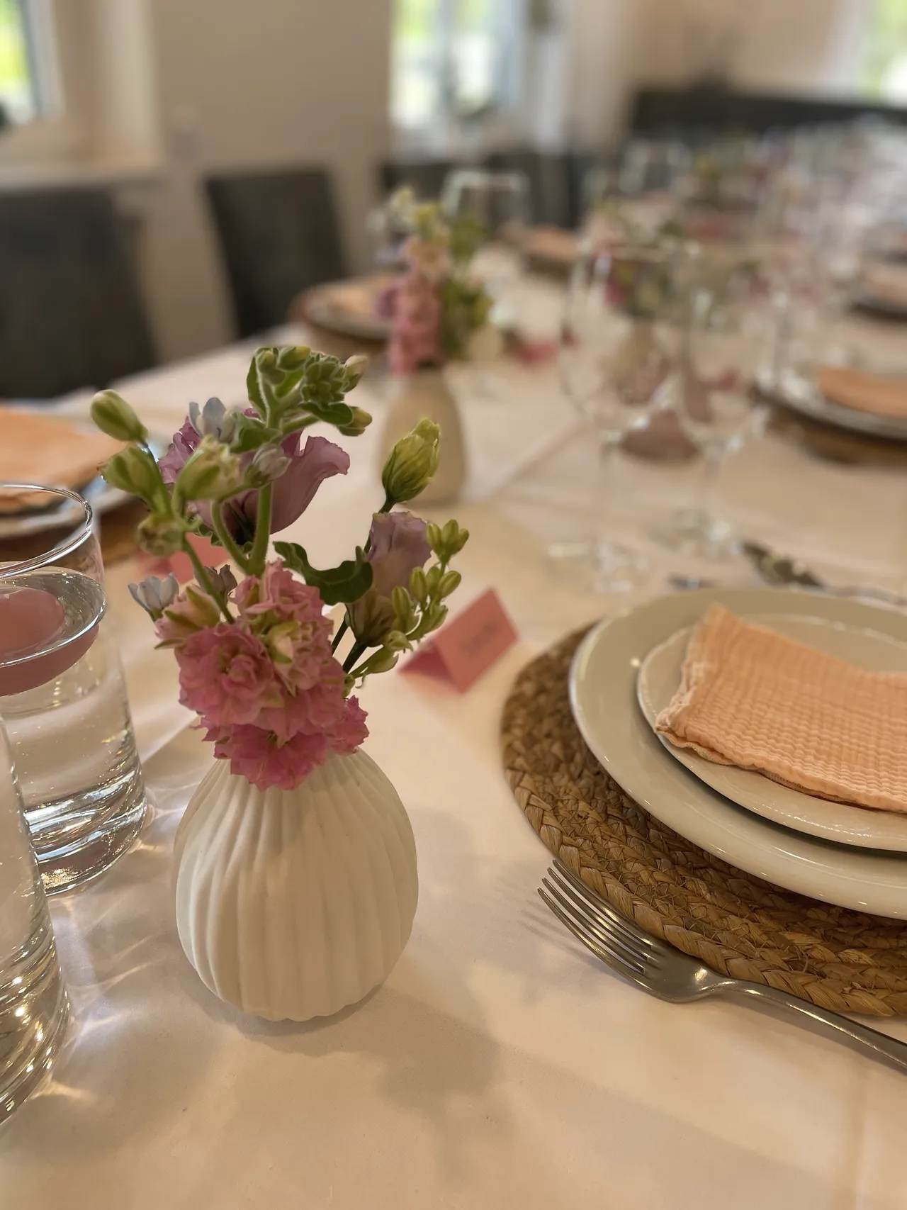 Gedeckter Tisch zum Kindergeburtstag mit rosa Blumen und Servietten