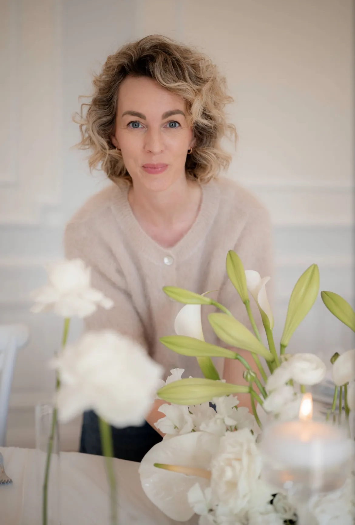 Mareen Hirschhäuser von Stil-Echt an einem Tisch mit weißen Blumen und Kerzen