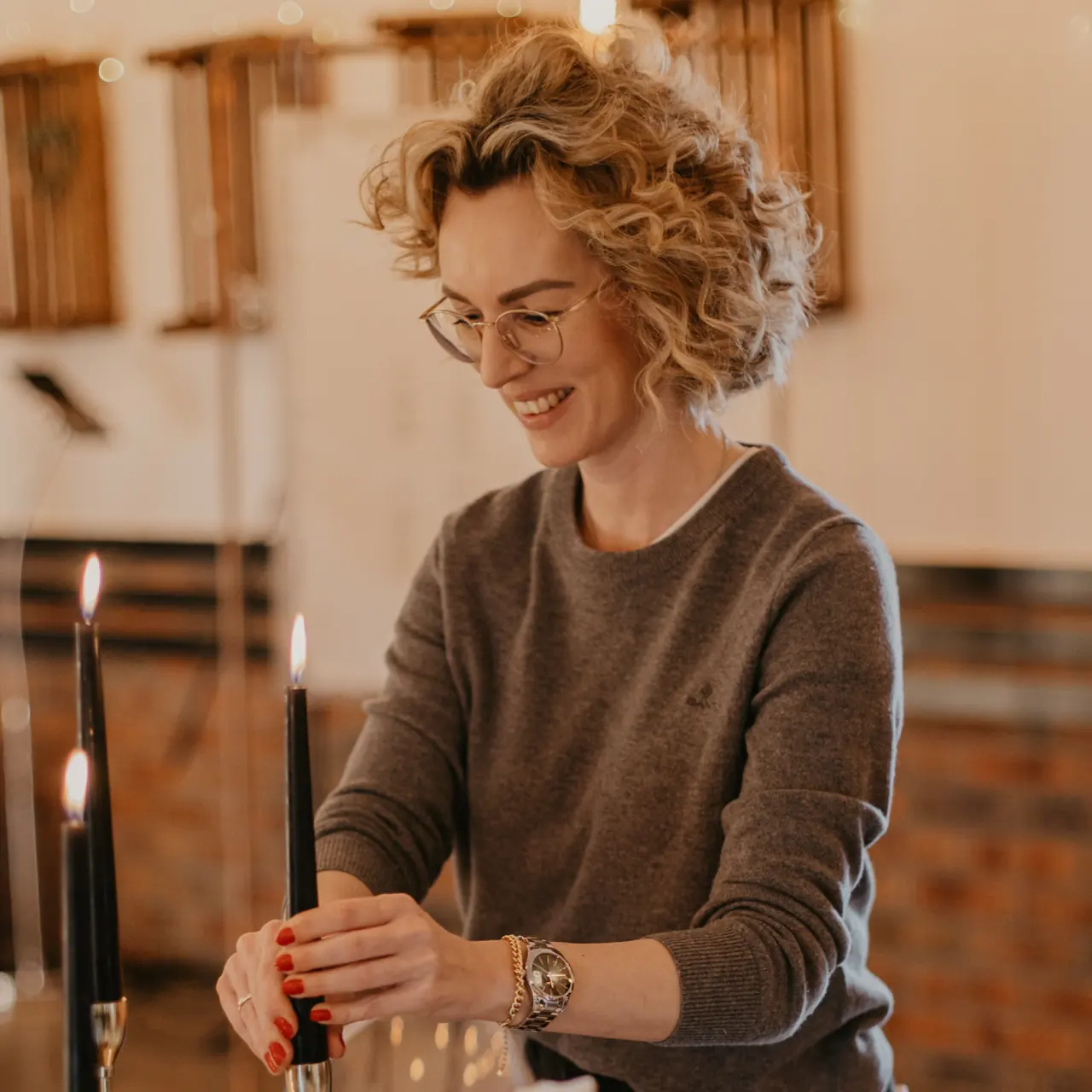 Mareen Hirschhäuser von Stil-Echt richtet Kerzen auf einer gedeckten Tafel