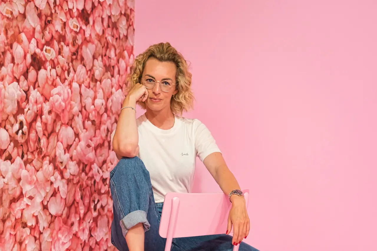 Mareen Hirschhäuser, Gründerin von Stil-Echt, sitzt vor einer Blumenwand