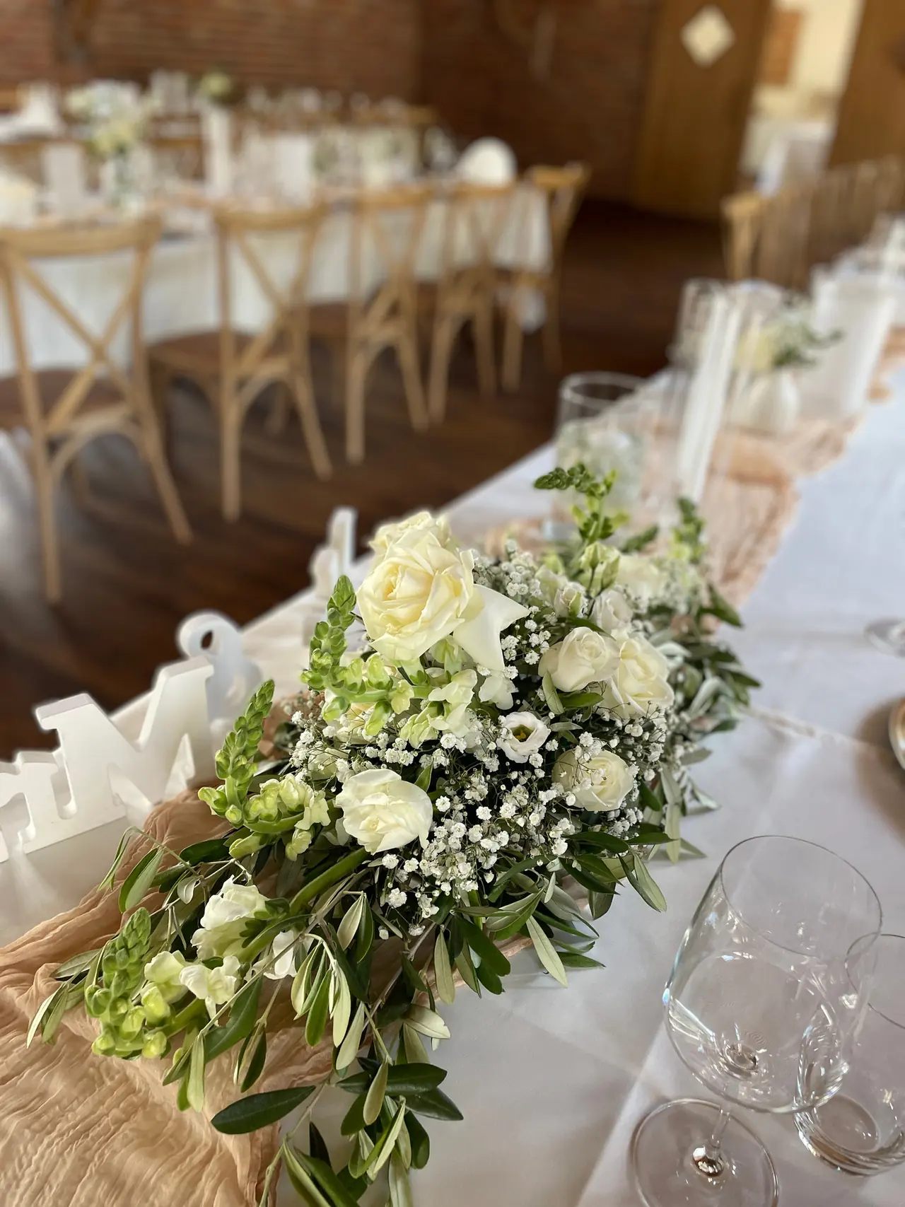 Tafel mit Girlande aus Grün und weißen Blumen